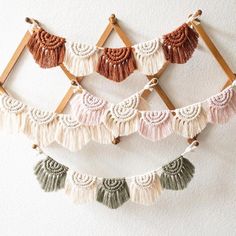 a wall hanging with tassels and wooden pegs on the top of it