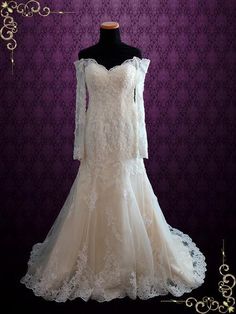 a white wedding dress with long sleeves on a mannequin head stand in front of a purple background