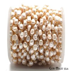 a white beaded bracelet with pearls and gold chains on it's end,