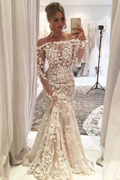 a woman is taking a selfie in her wedding dress, while she looks into the mirror