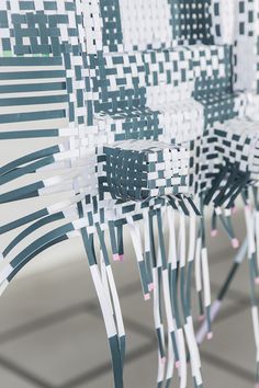 several chairs made out of strips of paper