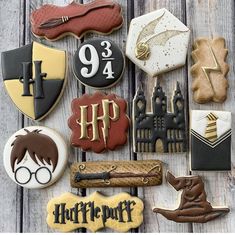 harry potter themed cookies are arranged on a wooden table with hogwart's crests