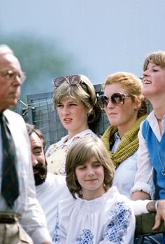 several women and one man are looking up at the sky with their heads tilted to the side