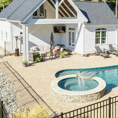 a house with a swimming pool in the middle of it and a patio area next to it