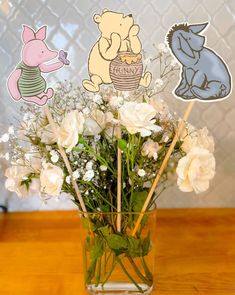 a vase filled with white flowers sitting on top of a wooden table next to stickers