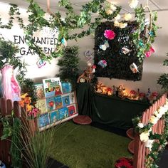 an indoor garden area with fake plants and pictures on the wall, surrounded by artificial greenery