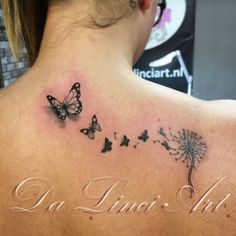 the back of a woman's shoulder with butterflies and dandelion