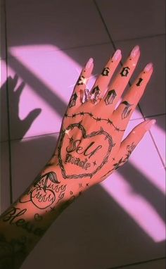 a person's hand with tattoos and numbers on it