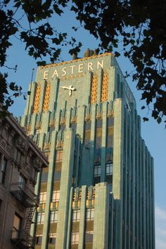 a tall building with a clock on it's side in front of a blue sky