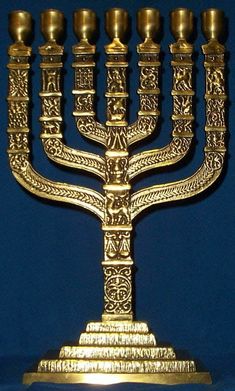 a golden menorah is on display against a blue background