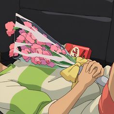 a person laying in bed with flowers on it