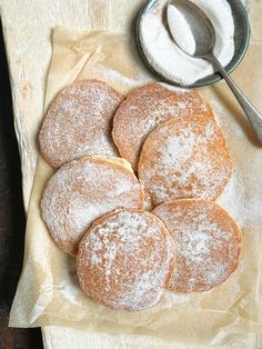 powdered sugar cookies are on a napkin next to a spoon