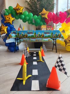 a birthday party with balloons, streamers and decorations in the shape of animals on a race track