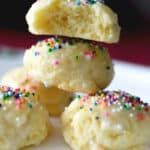 a white plate topped with donuts covered in frosting and sprinkles