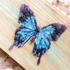 a blue butterfly sitting on top of a wooden board