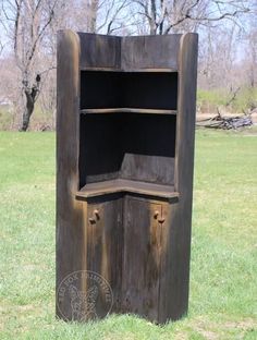 an old wooden cabinet sitting in the middle of a field