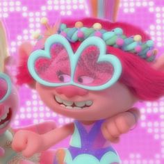 an animated character with pink hair and blue eye make up next to another character wearing sunglasses