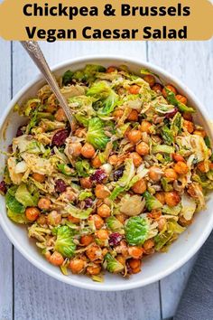 a white bowl filled with lettuce, carrots and chickpeas salad