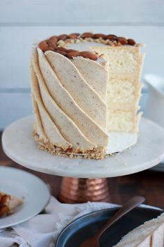 there is a white cake with nuts on the top and one slice missing from it