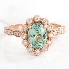 Oval seafoam green sapphire engagement ring rose gold vintage halo diamond sapphire ring la more design jewelry Oval Green Sapphire Ring With Halo Setting, Heirloom Green Oval Halo Ring, Oval Sapphire Diamond Ring, Sapphire Engagement Ring Gold, Green Sapphire Engagement, Green Sapphire Engagement Ring, Green Sapphire Ring, 3 Stone Rings, Vintage Style Rings