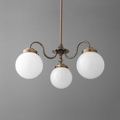 three light chandelier with white glass globes hanging from it's ceiling