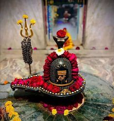 a decorative item is sitting on top of a table with flowers and other decorations around it