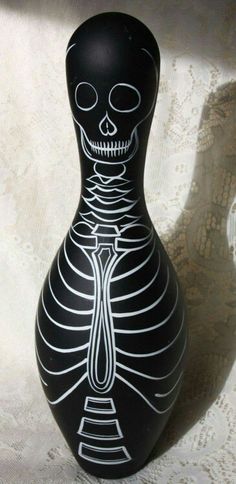 a black vase with a skeleton painted on it