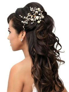 a woman with long dark hair wearing a wedding hairstyle and pearls in her hair