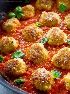 meatballs in tomato sauce with basil leaves and parmesan sprinkles