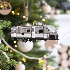 an ornament shaped like a travel trailer hanging from a christmas tree