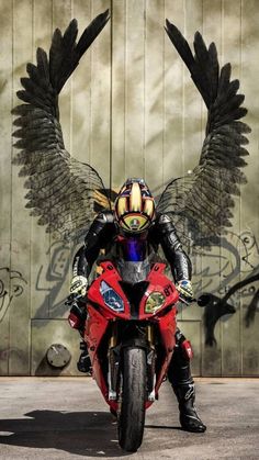 a person on a motorcycle with wings painted on the wall