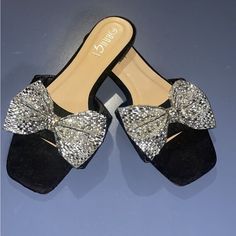 Black Slides With Rhinestone Bow Embelishment Size 7 Never Worn No Damages Comfy Cushion Inside Shoe Great For Dress Up Or Dress Down Shoes Are Sanitized And Ready For Shipping Party Flat Sandals With Bling, Flat Party Sandals With Bling, Glamorous Black Glitter Sandals, Glamorous Black Embellished Sandals, Black Sparkling Sandals For Party, Silver Sequined Sandals For Party, Glamorous Black Sandals With Bling, Party Silver Sandals With Sequins, Silver Sequined Party Sandals