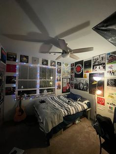 a bed room with a neatly made bed and lots of pictures on the wall