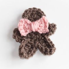 a crocheted teddy bear with a pink bow on it's head is shown