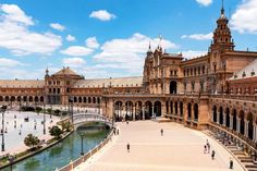 the plaza in front of an old building with water and people walking around it on a sunny day