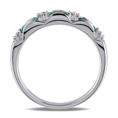 a white gold ring with green and white stones on the sides, set in 18k white gold