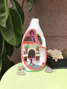 a bottle of liquid sitting on top of a table next to a potted plant