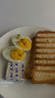 a white plate topped with an egg and two slices of toast next to a package of milk