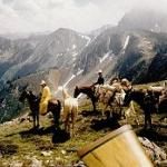 horses and riders on the side of a mountain