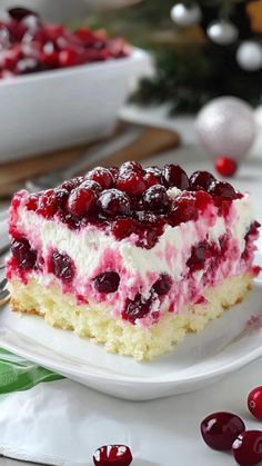 a piece of cake sitting on top of a white plate next to a bowl of cherries