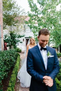 a man in a suit and tie standing next to a woman in a wedding dress