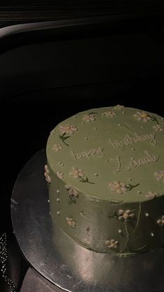 a green cake sitting on top of a metal plate