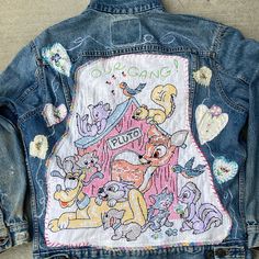 a denim jacket with embroidered pictures on it