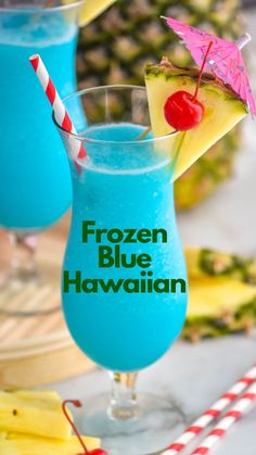 two glasses filled with blue hawaiian drink next to pineapples