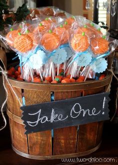 a basket filled with oranges wrapped in cellophane and labeled take one on it