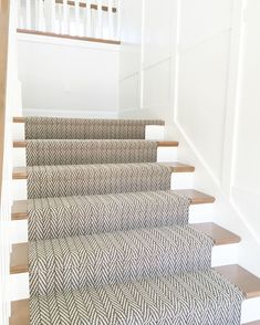 a set of stairs with carpeted treads and handrails in a house