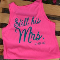 a pink tank top with the words still his mrs on it sitting on a bench