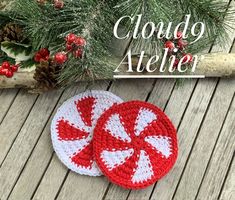 two crocheted coasters sitting on top of a wooden table next to pine cones