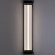 a wall mounted light that is on the side of a wall in an empty room