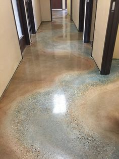 an empty hallway with several doors and two urinals on either side of the door